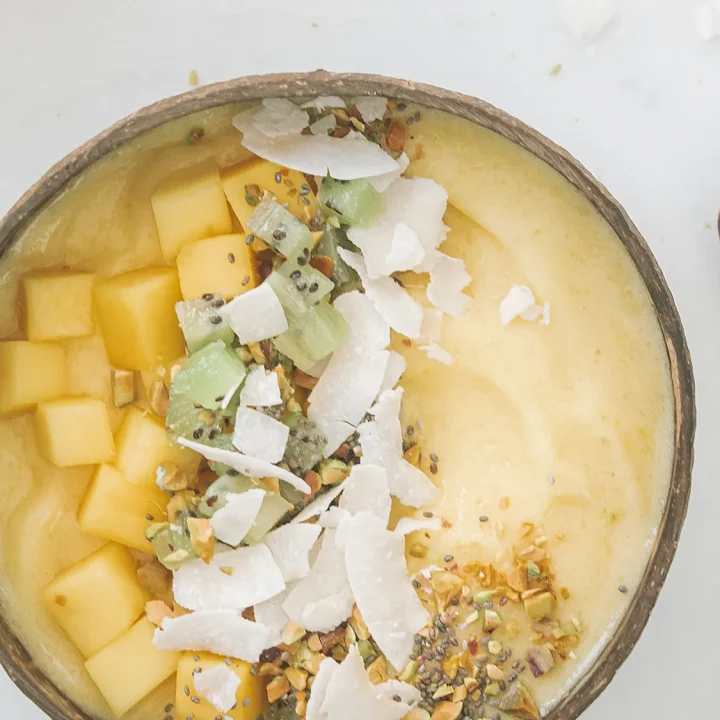 Tropical Mango and Pineapple Smoothie Bowl Recipe with Coconut Flakes.