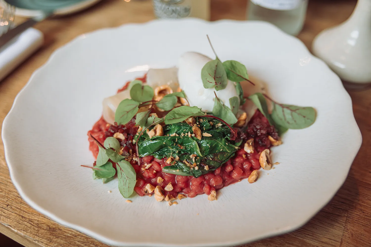 Elegant vegan fine dining dish at Acorn Vegetarian Kitchen in Bath, featuring seasonal vegetables, herbs and plant-based ingredients on a white plate.