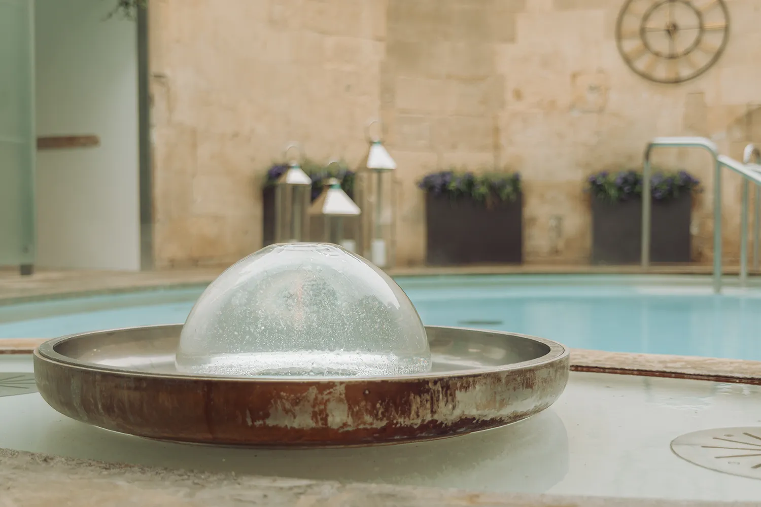 Bubbling thermal water fountain at the Cross Bath at The Thermae Bath Spa in Bath, England.